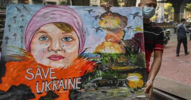 Um professor de arte carrega uma pintura para condenar a operação militar da Rússia na Ucrânia, em Mumbai, na Índia