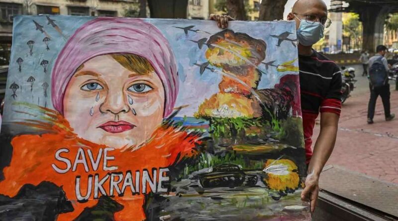 Um professor de arte carrega uma pintura para condenar a operação militar da Rússia na Ucrânia, em Mumbai, na Índia