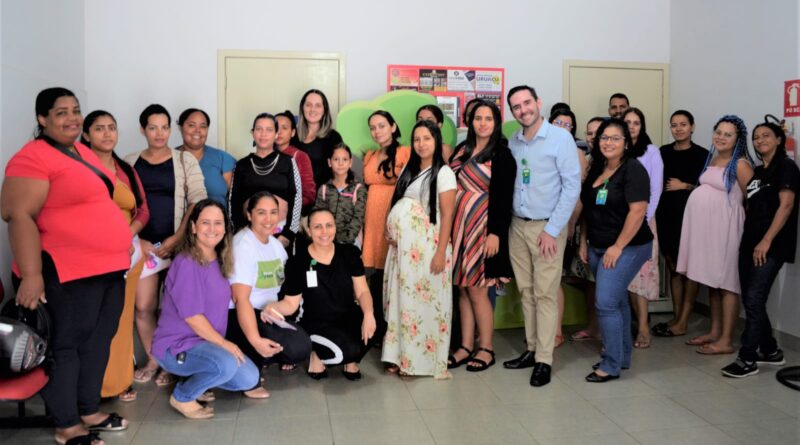 Esta imagem contém, dois homens e várias mulheres posando para a foto lado a lado e algumas abaixadas. Entre essas pessoas estão mulheres gestantes no HCN, violência obstétrica, parto humanizado