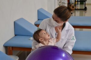 Fisioterapeuta realiza exercício com bebê em sala de terapia infantil da Policlínica Estadual da Região do Entorno – Formosa, unidade gerida pelo Instituto de Medicina, Estudos e Desenvolvimento - IMED