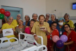 Celebração de aniversário e alta hospitalar de paciente com uma festa organizada pela equipe do Hospital Estadual de Trindade - Hetrin, destacando a importância da humanização no atendimento.