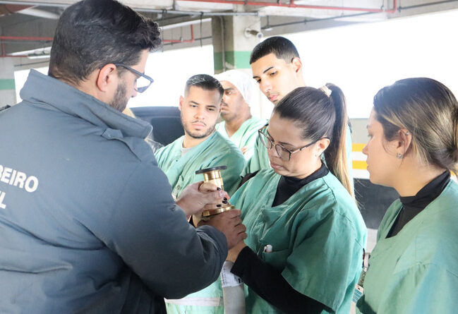 Imagem de colaboradores do Hospital Municipal da Brasilândia (HMB) durante o treinamento de brigada de incêndio, com atividades práticas de combate a princípios de fogo e primeiros socorros.