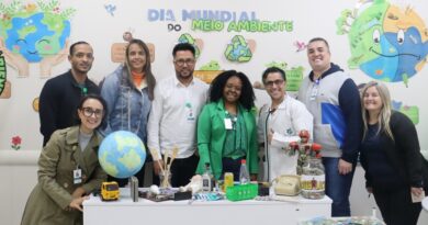 Imagem de colaboradores do Hospital Municipal da Brasilândia (HMB) participando do projeto "Salvei uma Orquídea", onde recebem mudas e aprendem sobre práticas sustentáveis.