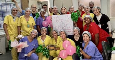 Mini texto alternativo (imagem): Profissionais do HEF aplaudem paciente em corredor de homenagem após sete meses de internação e recuperação.