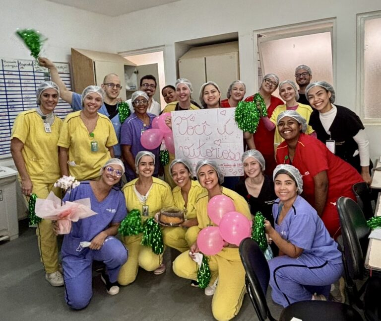 Mini texto alternativo (imagem): Profissionais do HEF aplaudem paciente em corredor de homenagem após sete meses de internação e recuperação.