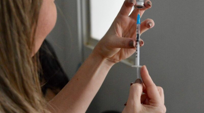 Profissional de saúde do HEF aplica vacina contra gripe em paciente, reforçando medidas de prevenção no outono/inverno.